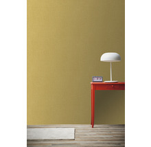 Intérieur avec papier peint intissé doré, table rouge, lampe et horloge