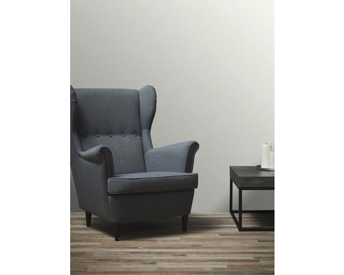 Wohnzimmer mit Sessel und Beistelltisch mit Kerzen