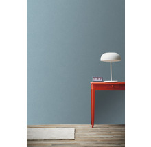 Scène avec table rouge, lampe blanche et horloge devant un mur