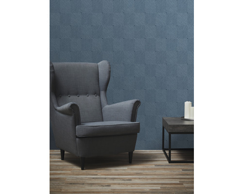 Wohnzimmer mit Ohrensessel, Beistelltisch und gemusterter Tapete