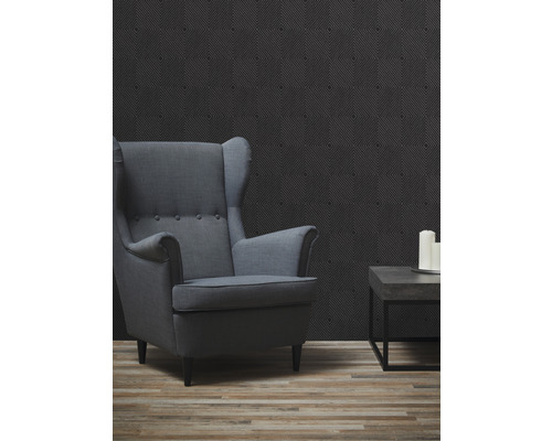 Wohnzimmer mit Sessel, Beistelltisch und geometrischer Tapete