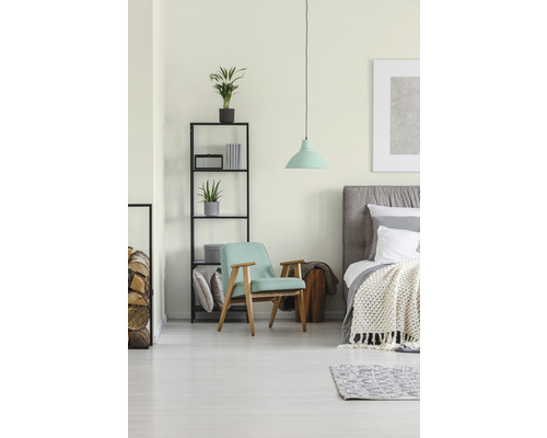 Helles Schlafzimmer mit Bett, Sessel, Regal und Pendelleuchte