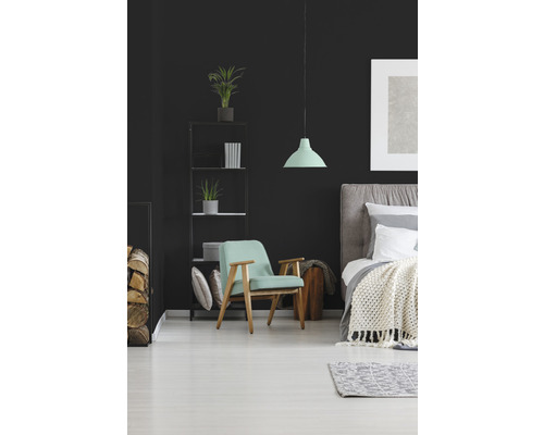 Schlafzimmer mit Bett, Sessel und Regal