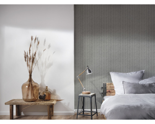 Schlafzimmer mit gemusterter Tapete, Bett, Lampe und Dekoration