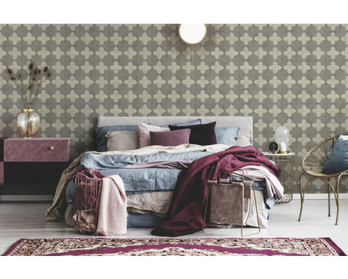 Schlafzimmer mit gemusterter Tapete, Bett, Nachttisch und dekorativen Accessoires für eine gemütliche Atmosphäre.