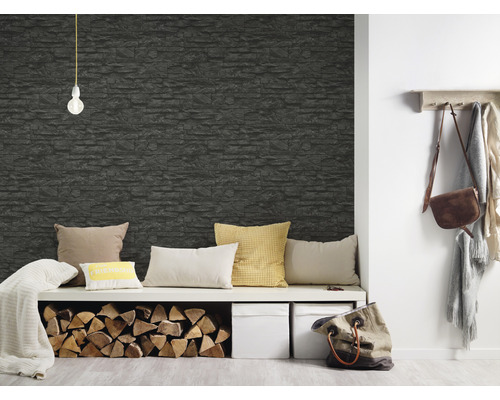 Espace de vie avec un revêtement mural en aspect pierre, un banc, des coussins et du bois de chauffage.