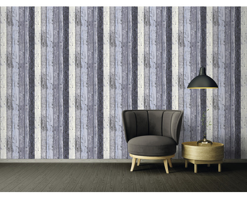 Wohnzimmer mit Sessel, Lampe und Wandtapete in Holzoptik