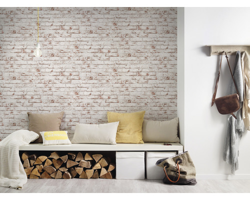 Espace de vie avec banc, coussins, pile de bois, boîtes de rangement et papier peint en briques