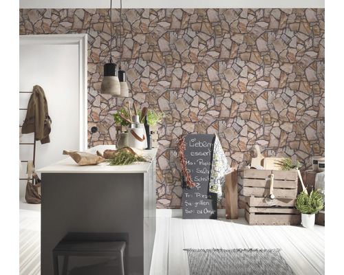 Cuisine lumineuse avec papier peint imitation pierre, îlot de cuisine et éléments décoratifs.