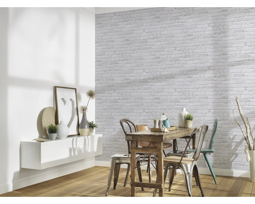 Salle à manger avec table, chaises et mur aspect pierre