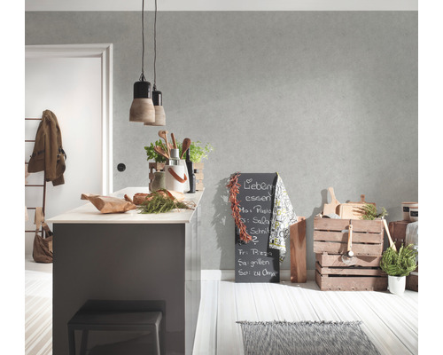 Cuisine claire avec îlot central, tableau noir et éléments en bois pour une ambiance conviviale.