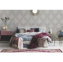 Schlafzimmer mit Tapete mit Ornamentmuster, Bett und Beistelltisch