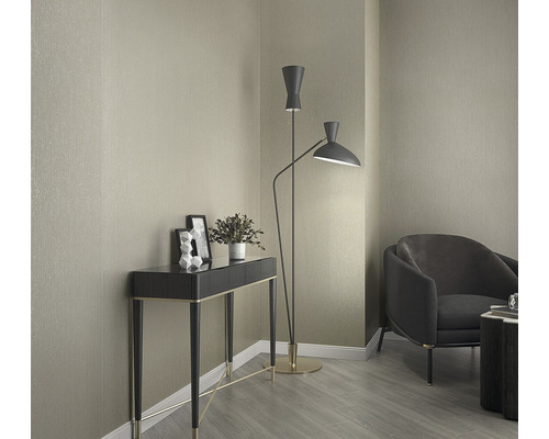 Innenraumansicht mit Konsole, Stehlampe und Sessel vor einer tapezierten Wand.