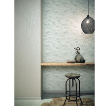 Wohnraum mit gemusterter Tapete, Holzbord, Hocker und Dekoration