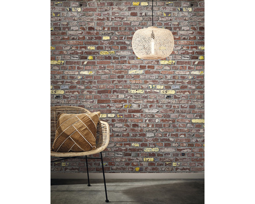 Dekorative Szene mit einer Ziegelwand, einem Rattansessel mit Kissen und einer Hängelampe