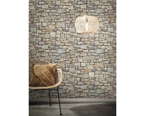 Dekoratives Interieur mit Steintapete, Rattansessel, Kissen und Hängelampe