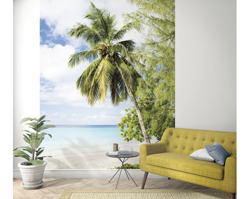 Papier peint photo avec motif de plage, comprenant un palmier et un canapé dans le salon