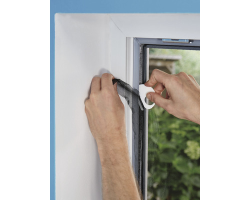 Montage eines Fliegengitters am Fensterrahmen mit Werkzeug