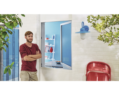 Un homme se tient devant une maison avec une moustiquaire et une lampe d''extérieur