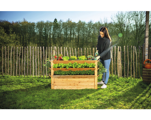 Hochbeet aus Holz mit drei Ebenen und Frau bei der Gartenarbeit