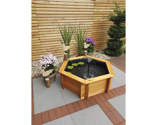 Fontaine hexagonale en bois dans le jardin avec jeux d''eau et décoration