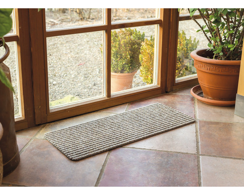 Paillasson devant une porte de terrasse sur un sol carrelé