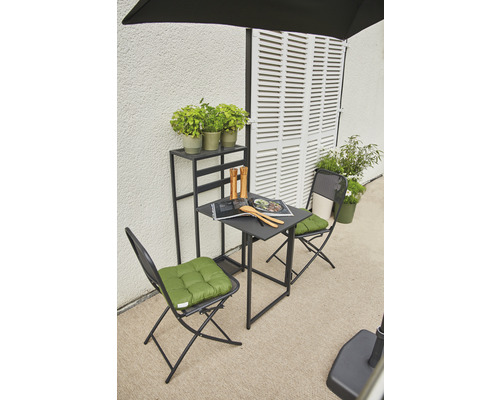 Scène de jardin avec table, chaises, plantes et étagère devant un mur