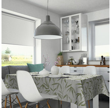 Salle à manger lumineuse avec table, chaises et nappe à motifs végétaux