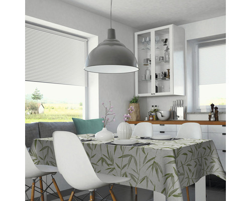 Salle à manger lumineuse avec table, chaises et nappe à motifs végétaux