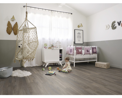 Kinderzimmer mit Hängesessel, Kinderbett und Spielzeug auf Holzboden