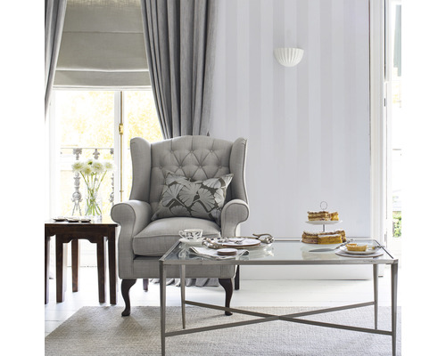 Salon avec fauteuil, table basse, rideaux et décoration