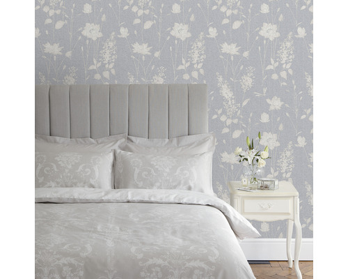 Schlafzimmer mit Bett, Nachttisch und Blumentapete