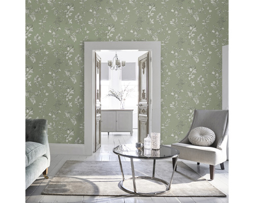Wohnzimmer mit floral gemusterter Tapete, Sessel und Tisch