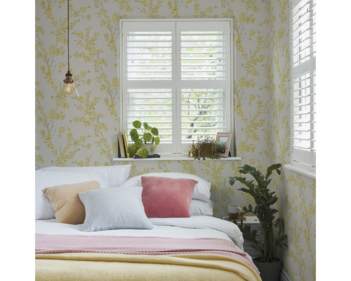 Schlafzimmer mit Bett, Kissen, Fensterläden und floraler Tapete