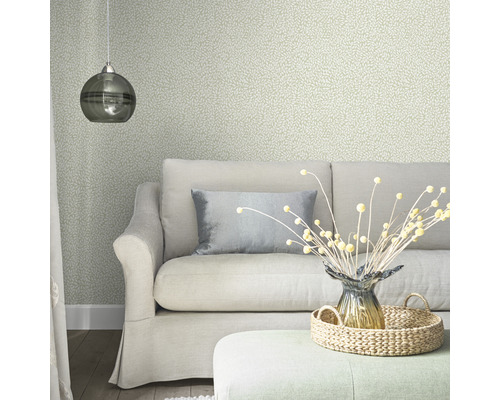 Wohnzimmer mit Sofa, Kissen, Lampe, Dekoration und gemusterter Tapete.