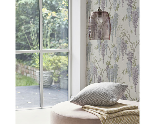 Zimmer mit Fenster, floraler Tapete, Lampe, Kissen und Hocker