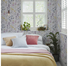 Chambre avec papier peint à fleurs, lit, coussins et fenêtre avec volets