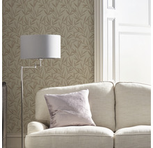 Salon avec canapé, lampadaire et papier peint à motif de feuilles