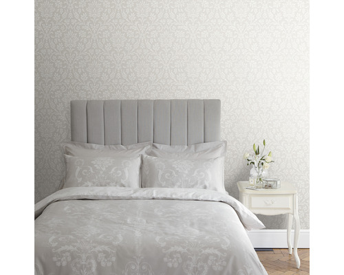 Chambre avec papier peint à motifs floraux, lit et table de chevet