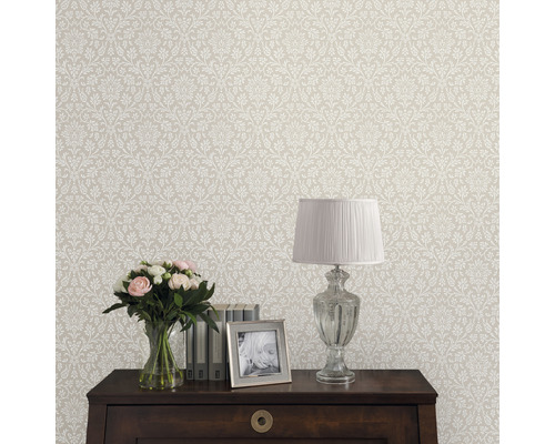 Papier peint à motif floral dans un intérieur avec table, lampe, fleurs et cadre photo