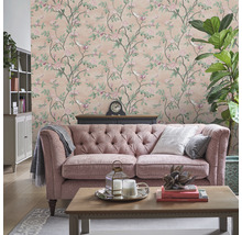 Salon avec papier peint floral, canapé et décorations pour une ambiance cosy