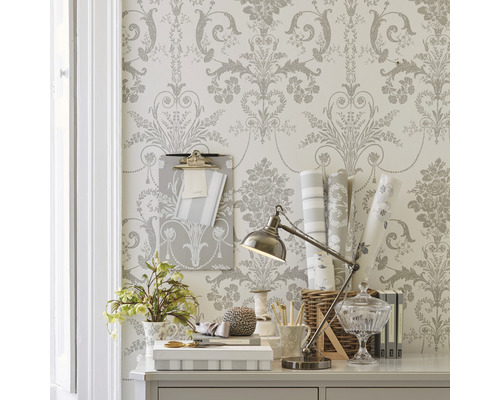 Dekorativer Schreibtisch mit Blumentapete, Schreibtischlampe und Büroartikeln