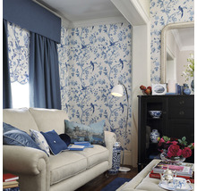 Salon décoratif avec canapé, armoire, lampadaire et papier peint à motifs