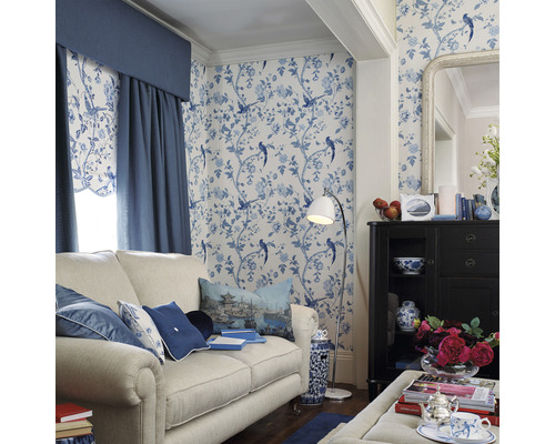 Dekoratives Wohnzimmer mit Sofa, Schrank, Stehlampe und gemusterter Tapete