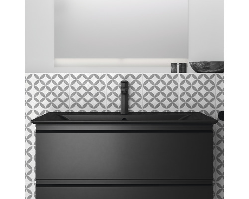 Meuble sous-vasque avec vasque, robinet et miroir devant un mur à motifs