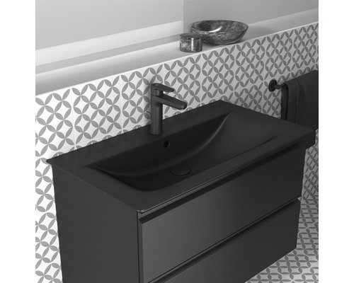 Meuble-lavabo noir avec deux tiroirs, robinet et porte-serviettes dans la salle de bain