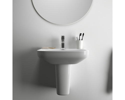 Waschbecken mit Armatur, Seife, Zahnbürsten und Spiegel im Badezimmer