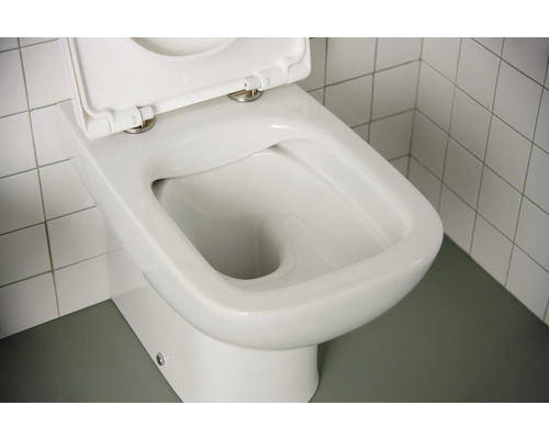 WC à fond creux blanc avec couvercle de toilette ouvert devant des carreaux muraux