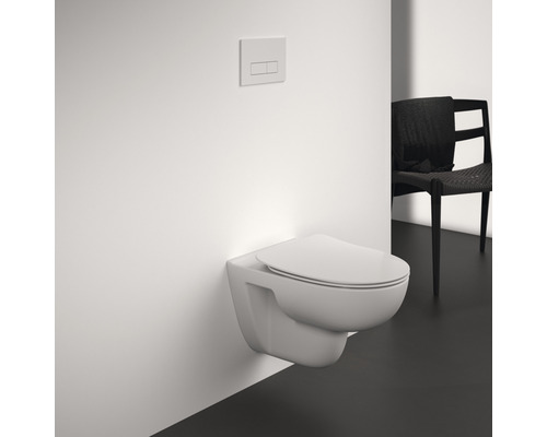 Wandhängendes WC mit Betätigungsplatte in einem Badezimmer.