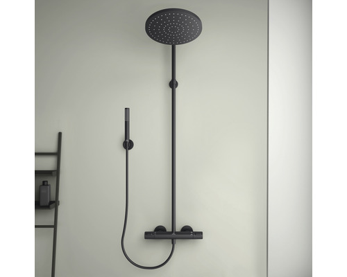 Schwarze Duscharmatur mit Kopf- und Handbrause an der Wand montiert.